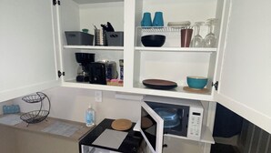 A compact kitchen with white cabinets, a microwave, and a coffee maker. - Luxury, cozy, and Charming studio with WiFi and AC in brilliant Tampa (Tampa)