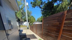 A narrow pathway with a wooden fence on one side and a building on the other. - Luxury, cozy, and Charming studio with WiFi and AC in brilliant Tampa (Tampa)