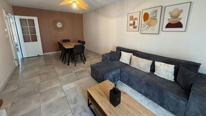 A modern living room with a sofa, coffee table, and dining table. - RESIDENCE STEPHANIE (Limoges)