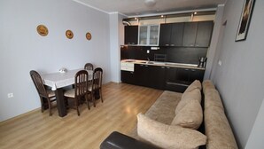 Un espacio habitable compacto con comedor, kitchenette y zona de estar.