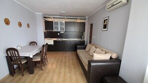 Un espacio habitable compacto con comedor, sofá y kitchenette.