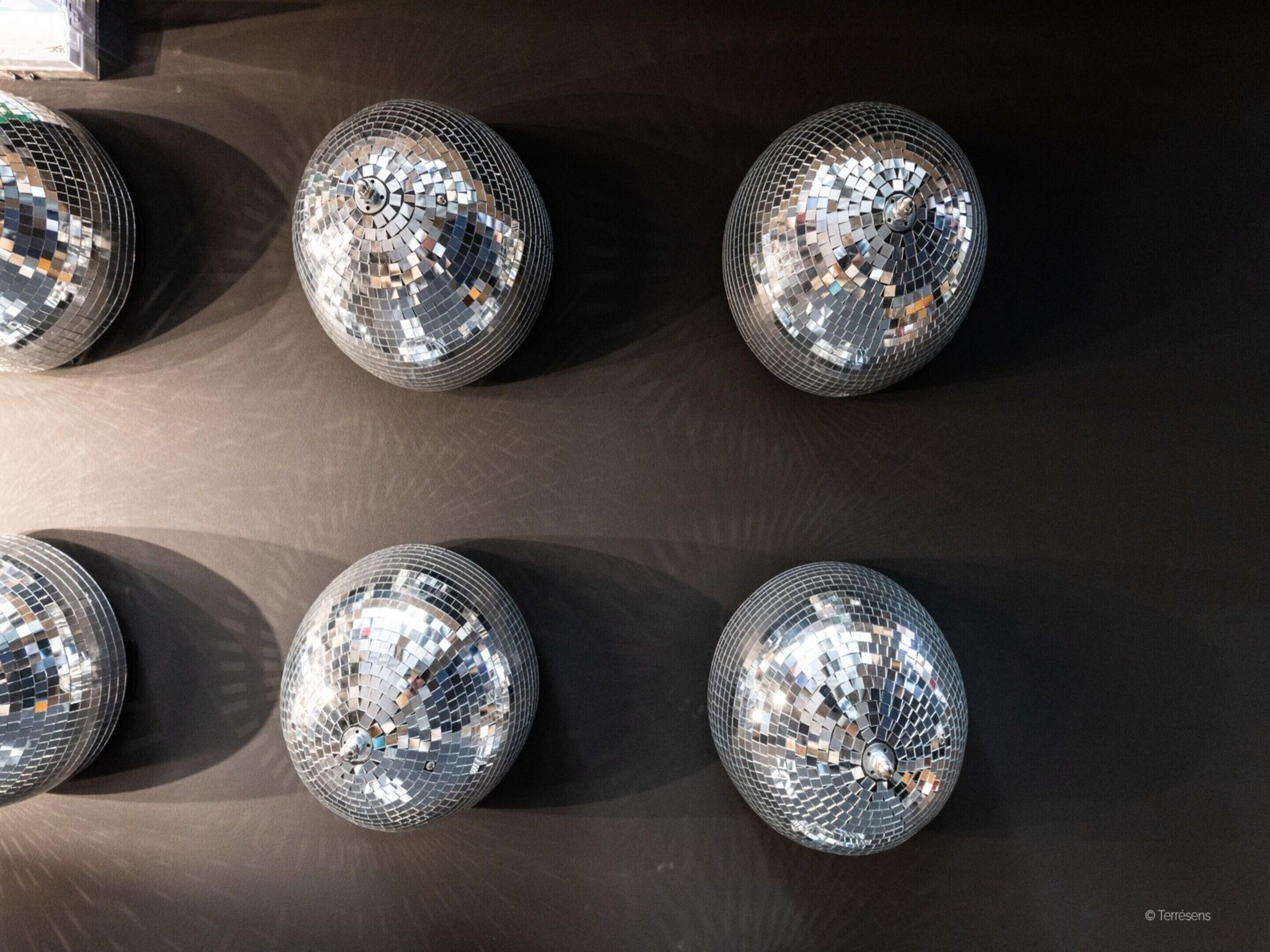 Six disco balls on a dark surface.