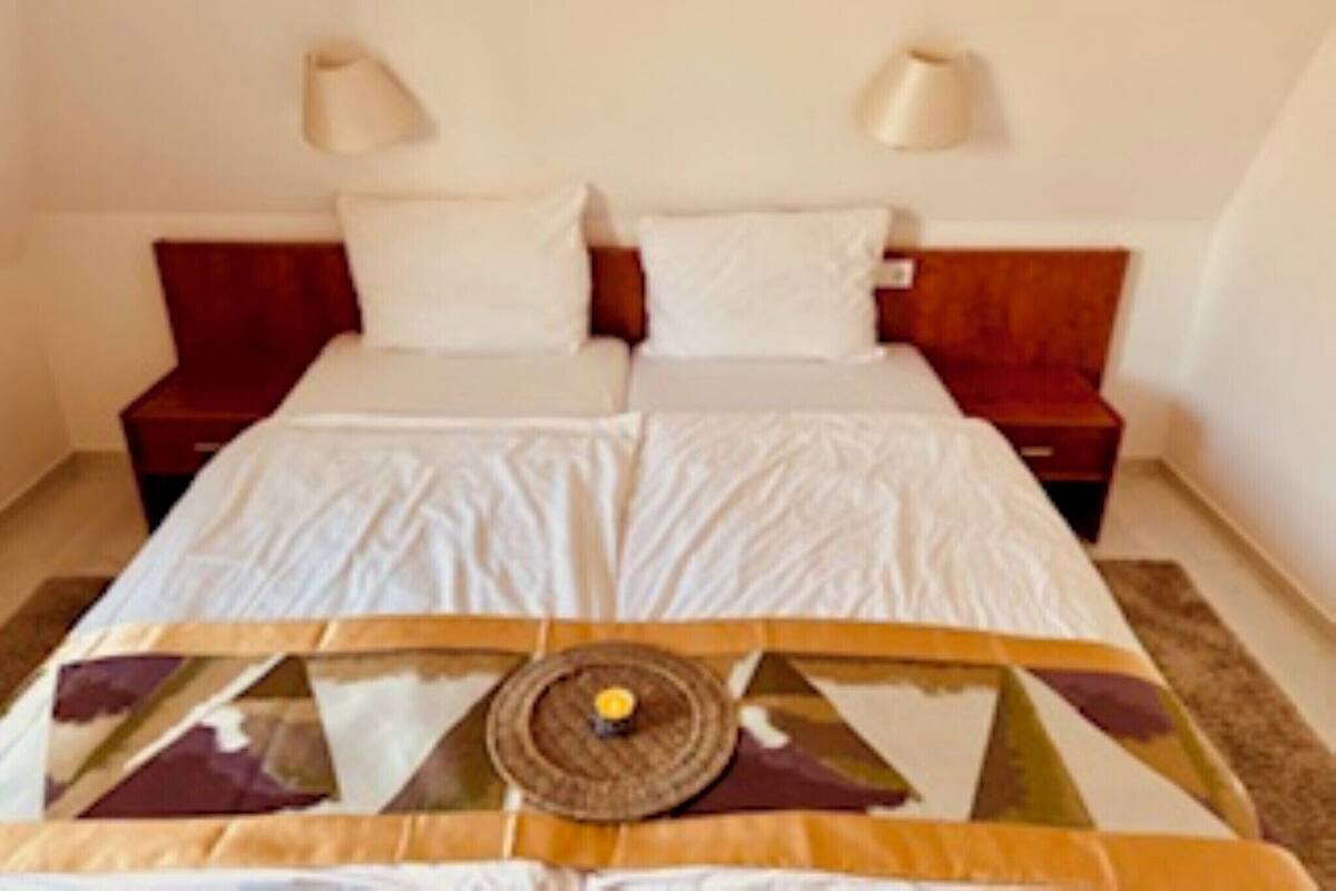 Ein Standard-Hotelzimmer mit einem Einzelbett, zwei Nachttischen und zwei Wandleuchten.