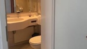 A bathroom with a double sink, a toilet, and a radiator. - Parkhotel & Kurcafe Bad Sassendorf (Bad Sassendorf)