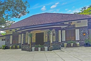 A two-story building with a tiled roof and stone facade. - Hotel O Bogor near Kebun Raya Bogor formerly Guest House Saputra (Bogor)