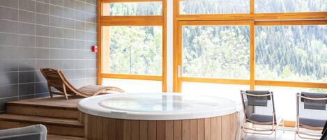 A spa area with a hot tub, wooden steps, and seating.