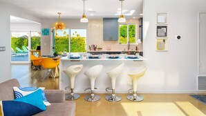 A modern kitchen with a central island, bar stools, and pendant lighting. - 25% Off 30+ Stay! Prime Location Private Pool, Spa (Palm Springs)