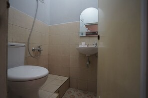 Ein kleines Badezimmer mit Toilette, Waschbecken und Dusche.