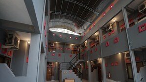 A multi-level interior with a staircase, a central table, and multiple air conditioning units. - Hotel O Palembang Near Bumi Sriwijaya Stadium Formerly HPA Homestay (Palembang)