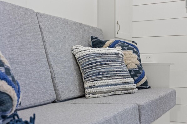 A grey sofa with two decorative pillows in shades of blue and white.
