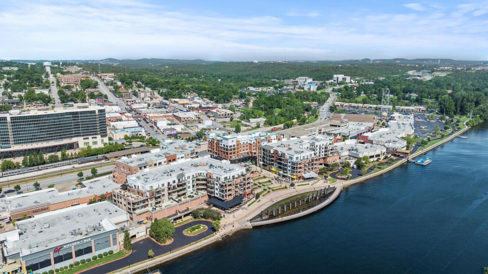 Un quartier urbain situé au bord de l’eau, avec des bâtiments modernes, un port de plaisance et une rivière.