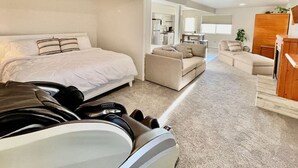 A modern hotel room with a large bed, a sofa, a dining area, and a kitchen in the background. - Spa Studio Retreat w/ Lake Access + Sauna & Jacuzzi (Kimberling City)