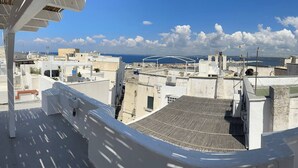 A rooftop terrace with a view of the sea and cityscape. - Corte Regi Appartment (Gallipoli)