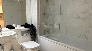Um banheiro moderno com pia, vaso sanitário e banheira brancos.