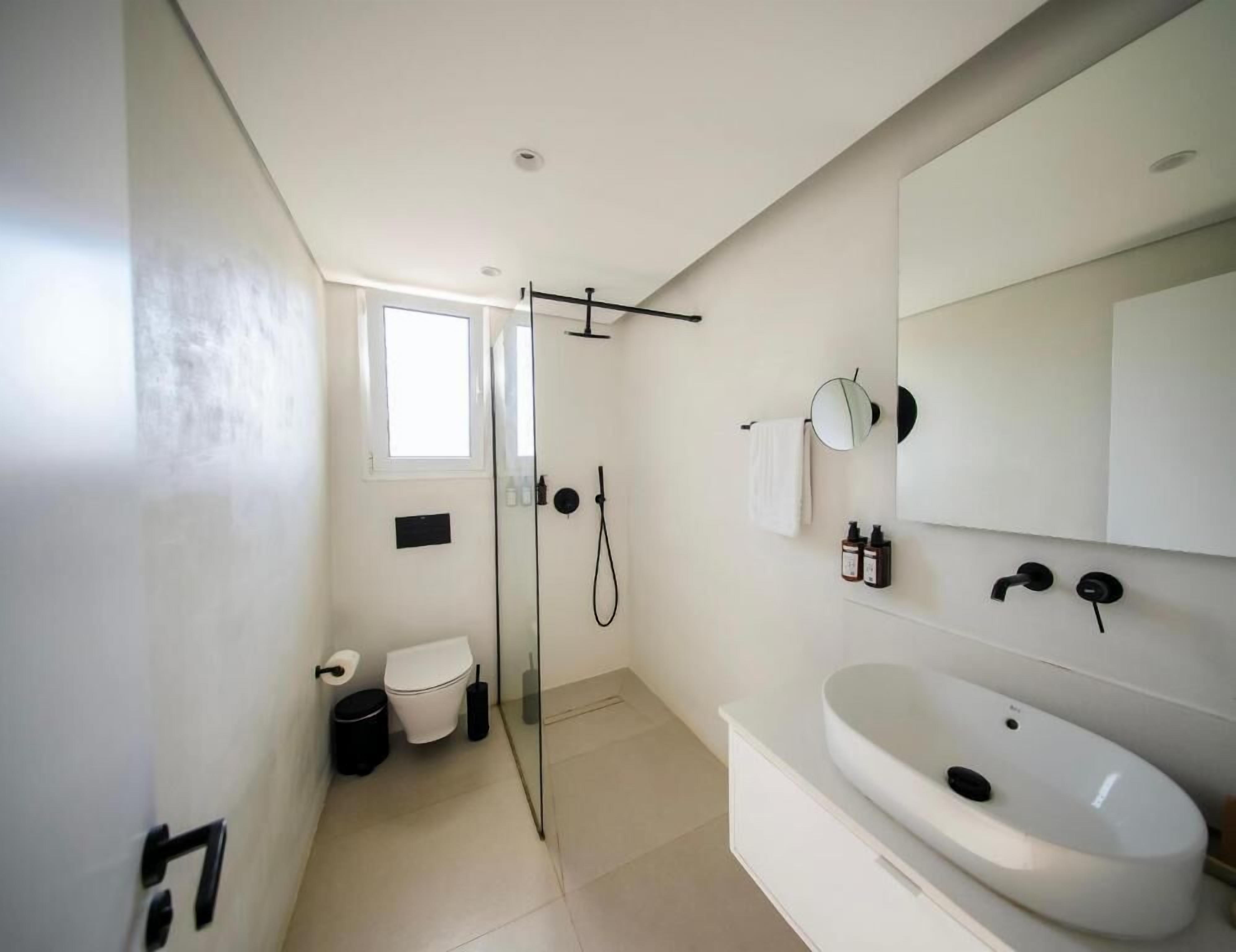 Un baño moderno con ducha, inodoro y lavabo.