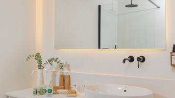 Un bagno moderno con un mobile lavabo bianco, uno specchio grande e un lavandino bianco.