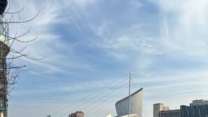 Un paseo fluvial con un puente moderno y edificios al fondo.