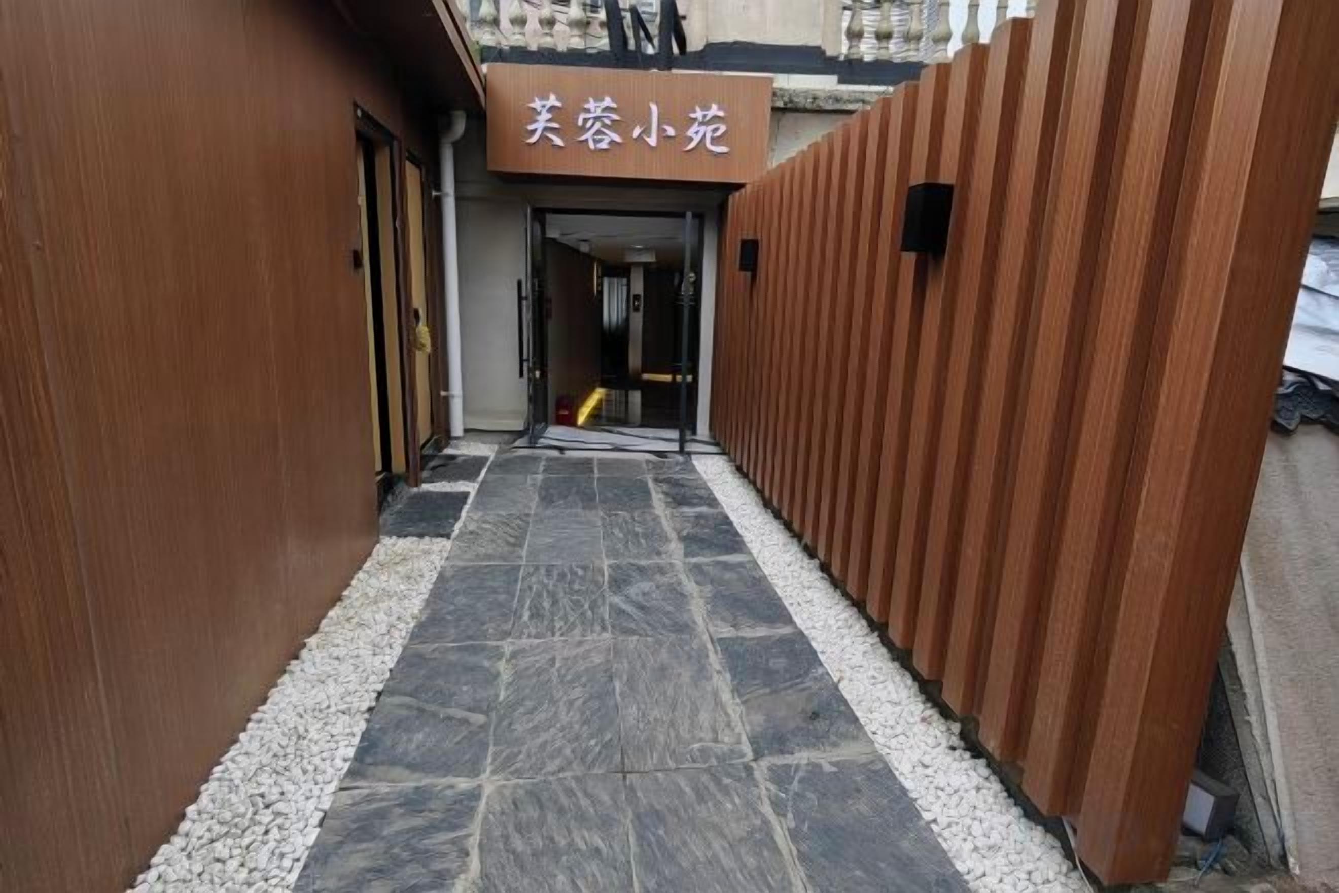 A corridor with a sign for 'Beauty Salon' and a wooden wall on one side.