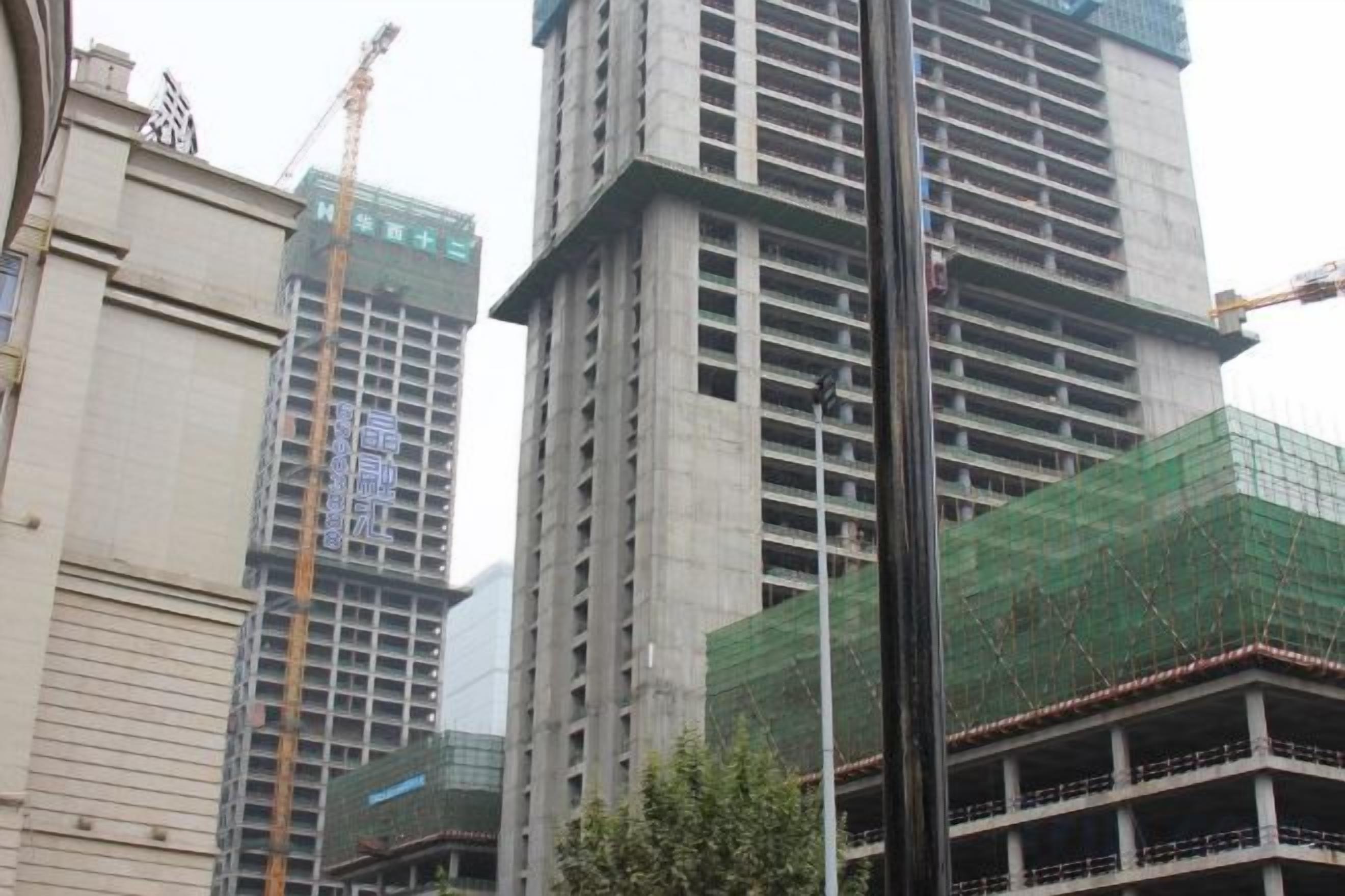A multi-story building with visible construction scaffolding and cranes, indicating ongoing development.
