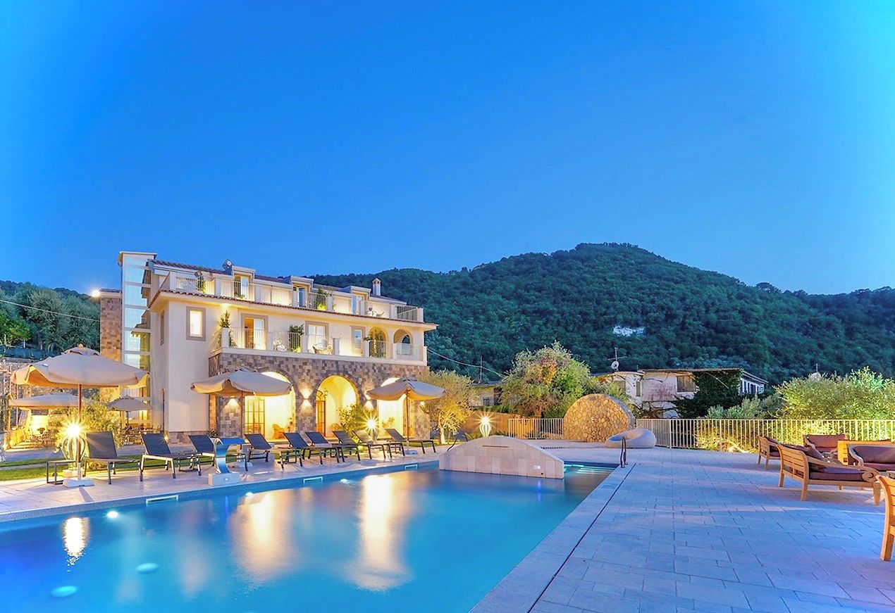 Un hôtel doté d’une piscine, de chaises longues et offrant une vue sur les montagnes.