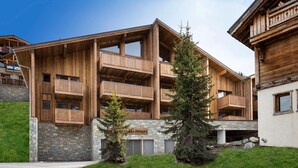 Un edificio in legno a più piani, con balconi e una base in pietra.