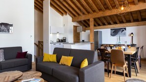 Un soggiorno moderno con un divano, un tavolino da caffè e un'area da pranzo.