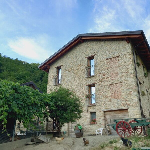 A stone building with multiple windows and a wooden roof. - Il Tesoro di Miro (Cartosio)
