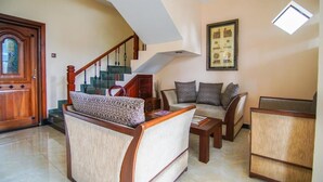 A spacious living room with a wooden staircase, a sofa set, and a framed picture on the wall. - Vivid Colombo (Colombo)