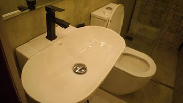 A bathroom with a white sink and a toilet.