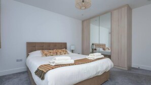Une chambre à coucher avec un grand lit, une armoire et un miroir.