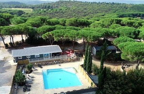 Une propriété résidentielle comprenant une piscine, une maison et des arbres environnants.