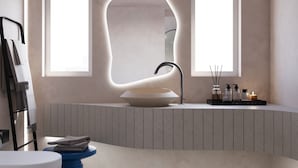 A modern bathroom with a freestanding bathtub, a toilet, and a sink. - You & Me Cove Imerovigli (Imerovigli)