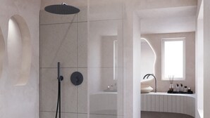 A modern bathroom with a glass-enclosed shower, a vanity with a sink, and a window providing natural light. - You & Me Cove Imerovigli (Imerovigli)