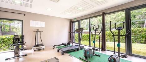 A gym with treadmills, elliptical machines, and weight equipment.
