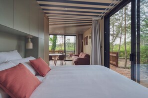 A bedroom with a large bed, a dining table, and a view of the outdoors. - BonjourSauvage Seignosse (Seignosse)