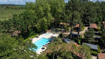 A residential area with a swimming pool, surrounded by trees and houses.