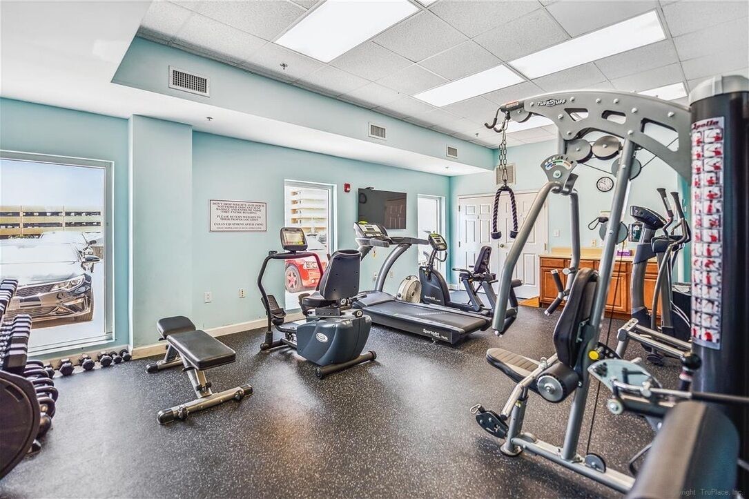 A gym with treadmills, elliptical machines, and free weights.