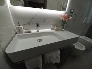 A bathroom with a white sink, a mirror, a toilet, and a vase with flowers. - Dorolea Rooms Torino Centro (Turin)