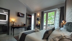 A hotel room with a bed, a desk, a TV, and a window with curtains. - Dorolea Rooms Torino Centro (Turin)