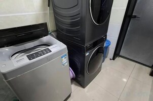 Un área de lavandería compacta con lavadora de carga frontal y secadora apilada.