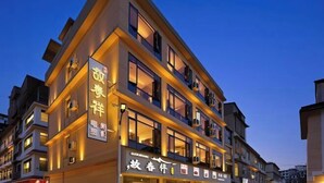 Un hotel de varios pisos con letreros iluminados y ventanas.