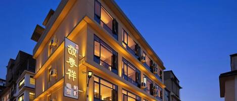 A multi-story hotel with illuminated signage and balconies.