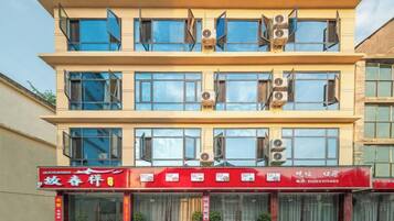 A multi-story building with a red storefront at the ground level.