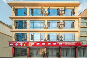 Un edificio de varios pisos con fachada roja en la planta baja.