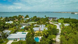 Un barrio residencial con casas, una piscina y vistas al mar.