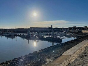 Un port de plaisance avec des bateaux amarrés, une eau calme et un ciel dégagé.