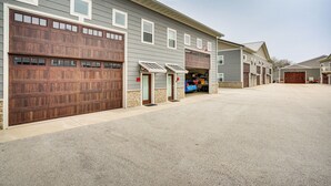 A residential building with multiple garage doors, a driveway, and a clear sky. - Home Near Road America & Elkhart Lake (Elkhart Lake)