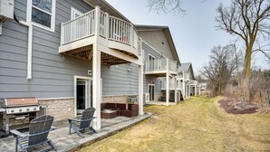 A residential building with a patio area featuring outdoor seating and a barbecue grill. - Home Near Road America & Elkhart Lake (Elkhart Lake)