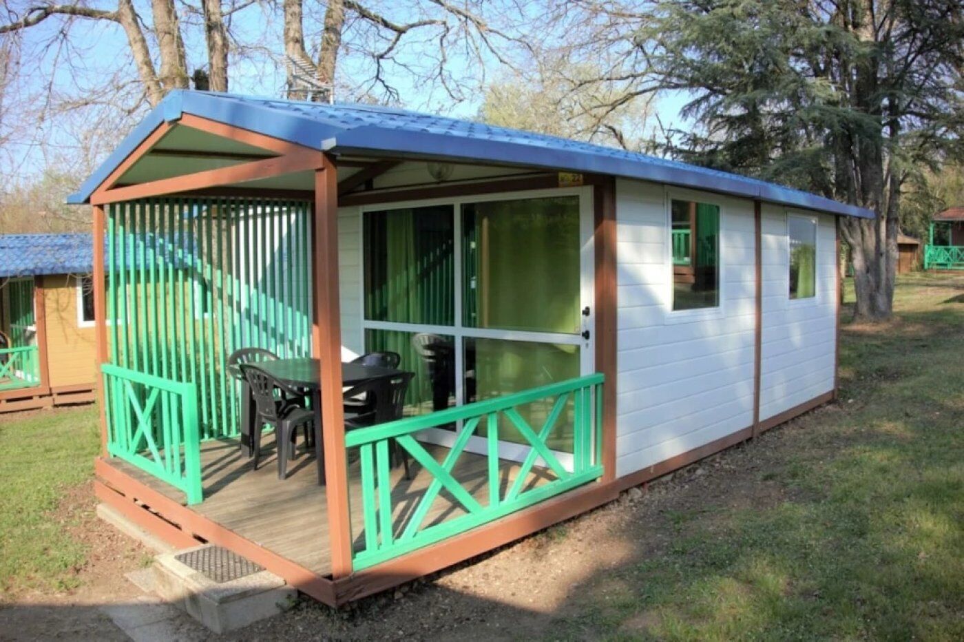 Une petite cabane à un seul étage, dotée d’un porche et d’un espace extérieur aménagé et abrité.