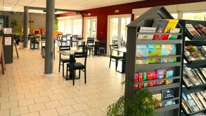 Une bibliothèque avec des étagères, des tables et des chaises.